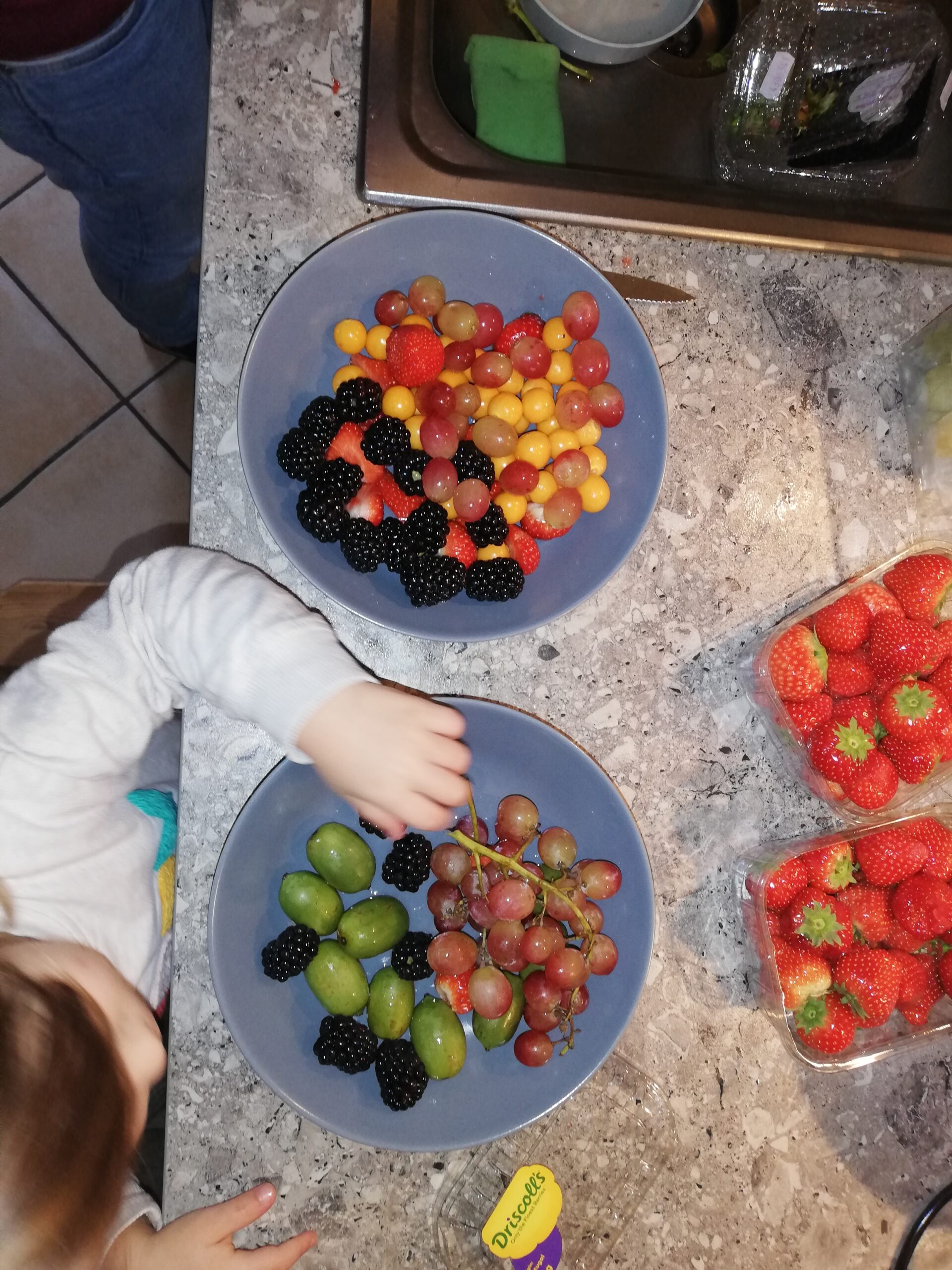kleine Kinderhände beim Obst naschen