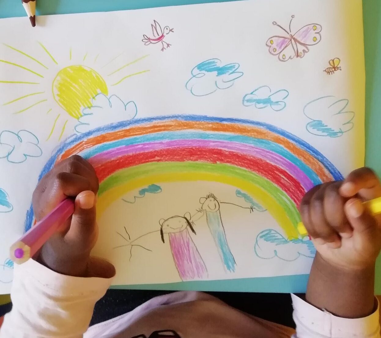 Kind beim Malen eines Regenbogens