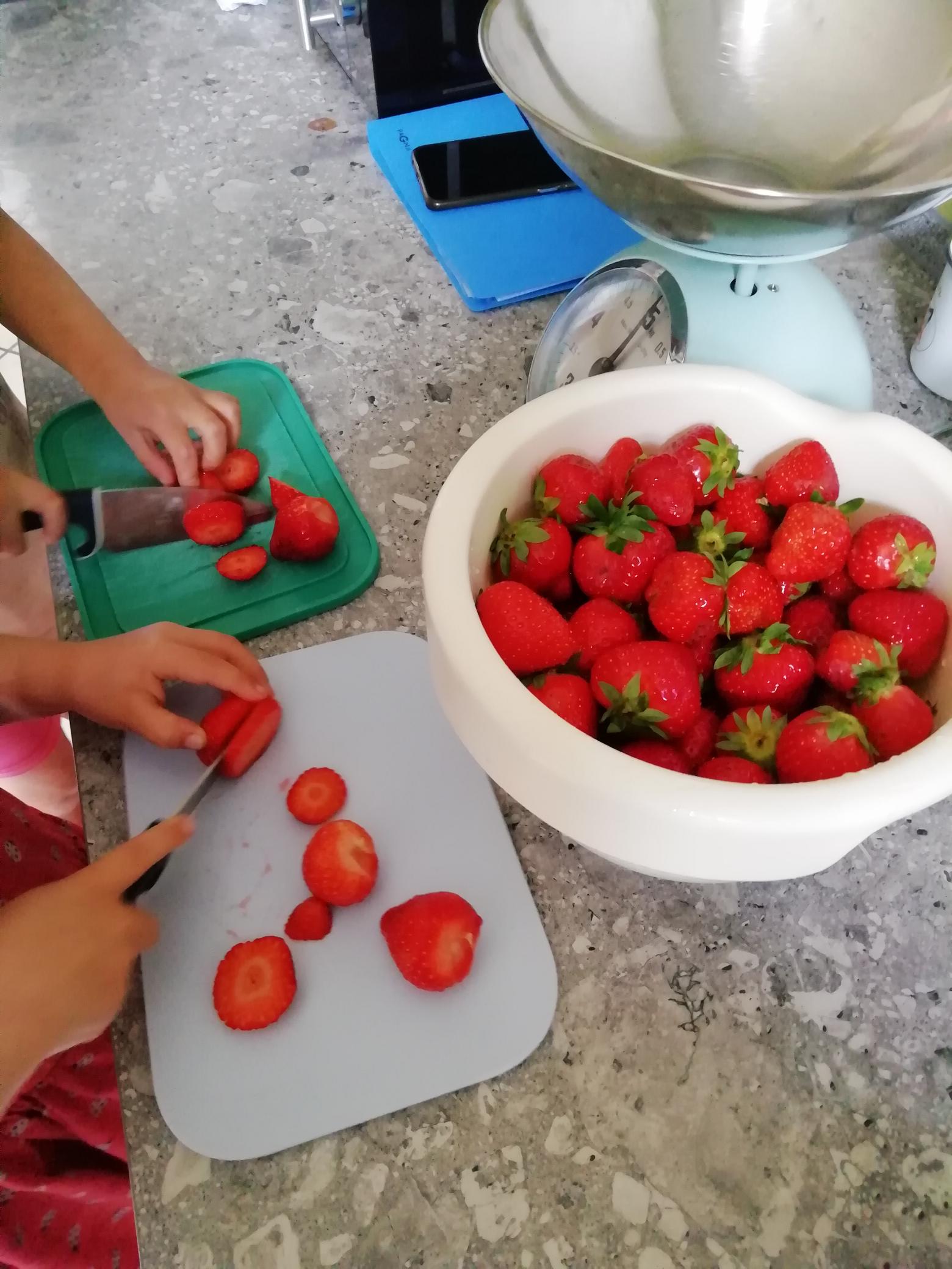 Kinder schneiden Erdbeeren