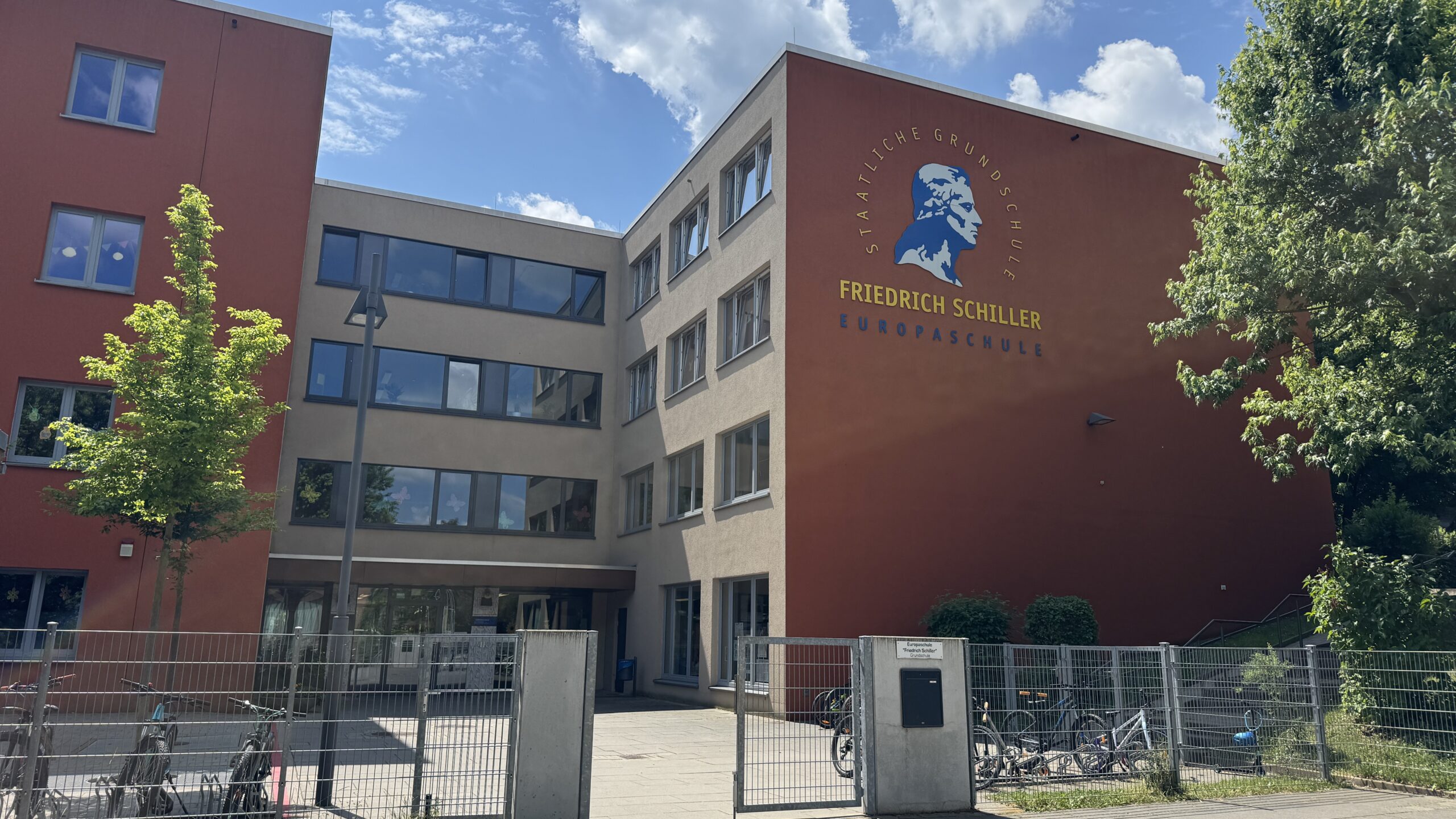 Schulgebäude der Staatlichen Grundschule Friedrich Schiller Europaschule mit Schriftzug und blauem Schillerporträt an der Fassade