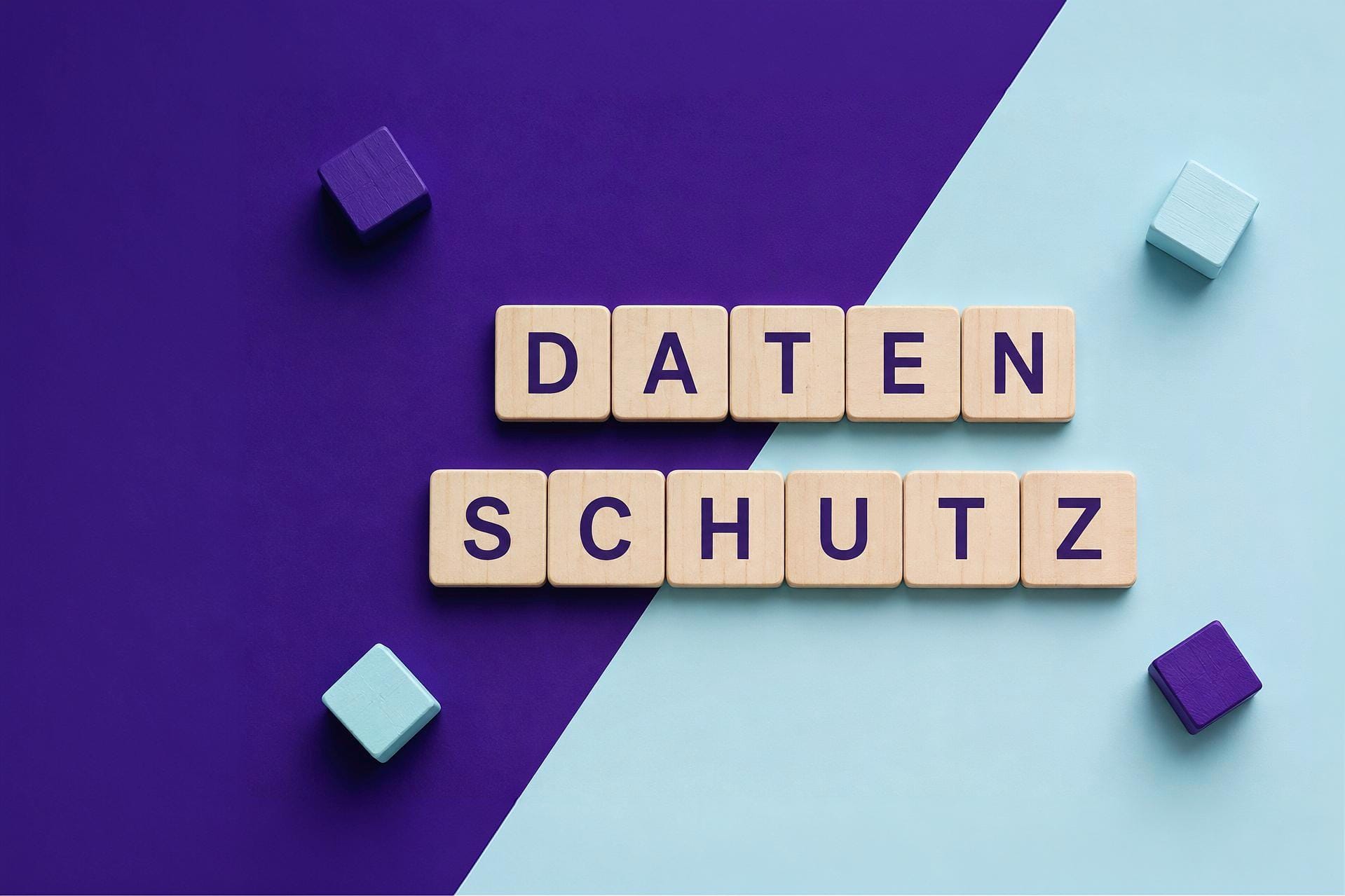 Holzwürfel bilden auf violett-blauem Hintergrund die Wörter "Datenschut"