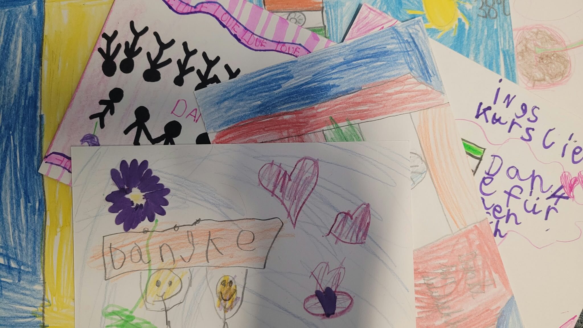 verschiedene bunte Motive von Kindern auf Postkarten, die übereinanderliegen
